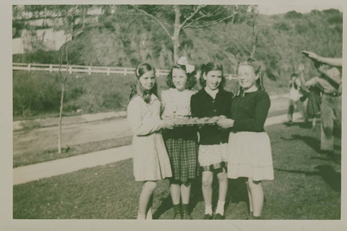 Girls holding a tray of bake sale goods for Canyon School in Santa Monica Canyon