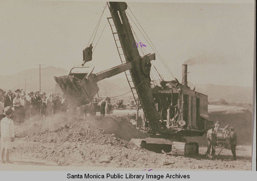 A crowd gathered by a steam shovel at the ceremonies marking the completion of grading on Beverly (Sunset) Blvd. from Los Angeles to Pacific Palisades, August 18, 1925