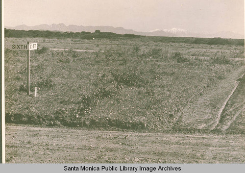 Early markers for "6th" and "C" Streets in Pacific Palisades looking toward a backdrop of snow capped mountains