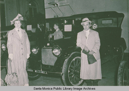 Man and a woman in costume with vintage automobiles, Pacific Palisades, Calif