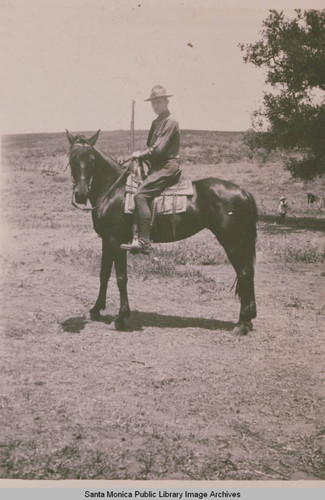 Clark Standiford on a horse next to an oak tree in Pacific Palisades, Calif