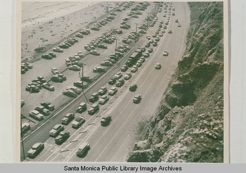 Pacific Coast Highway looking down from the Huntington Palisades at beach parking lots, May 30, 1951