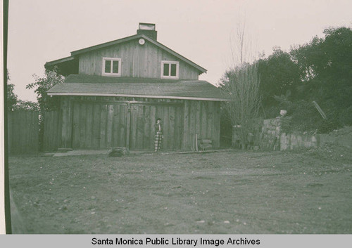 A woman standing in front of a house in Lachman Development after the landslide in Pacific Palisades