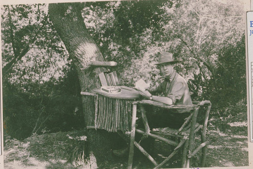 Scoutmaster reading under a tree at the camp in Temescal Canyon, Calif