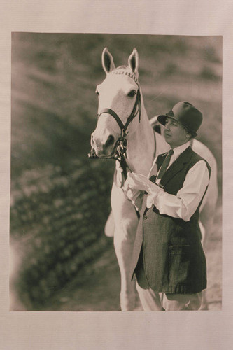 Betty Rogers, wife of Will Rogers in equestrian dress with her horse in Rustic Canyon, Calif