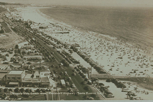 A crowded Will Rogers State Beach along the Roosevelt Highway (later became known as Pacific Coast Highway) looking south to Santa Monica, Calif