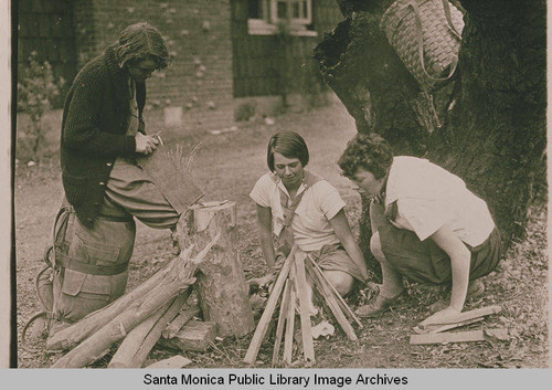 Three young girls (Girl Scouts) building a campfire in Temescal Canyon, Pacific Palisades, Calif