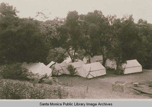 Tents and a barbecue are set up among the oaks at the Institute Camp, Temescal Canyon, Calif