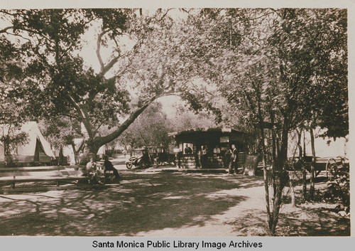 Car, casita, tent and camp office are in view among the oaks at Assembly Camp, Temescal Canyon, Calif