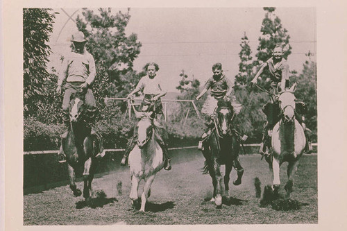 Will Rogers Family (left to right Will Sr., Mary, Jim, and Will Jr.) riding and roping at the Tan Bark Arena in Beverly Hills