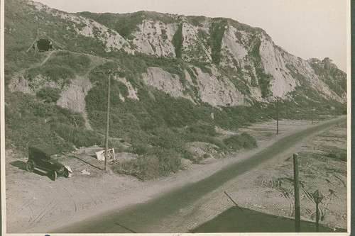 Automobile and litter by the one-lane road that would become Pacific Coast Highway