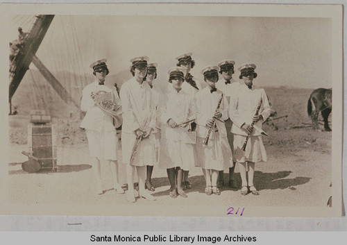 Pacific Palisades Womens' Band standing by a steam shovel with a mule in the background