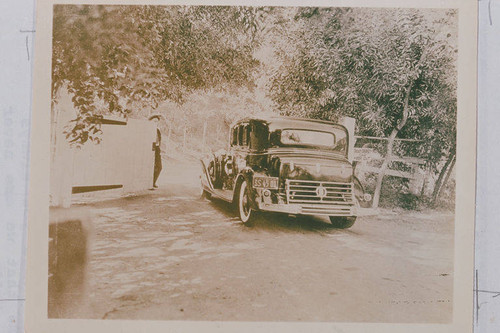 Automobile at the entrance gate of the Will Rogers Ranch, Rustic Canyon, Calif