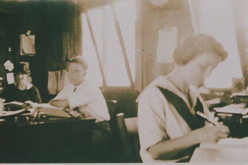 Rayburn Rust (center), Nellie Henderson (right) and another person in a Construction Camp office, Temescal Canyon, Calif