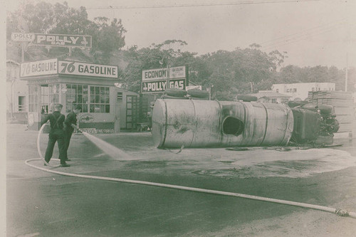 Workers dousing a hazardardous spill near an overturned truck at Polly 76 gas station in Pacific Palisades, Calif