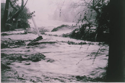 Flood damage at the intersection of East Rustic Road and West Channel Road in Pacific Palisades, Calif