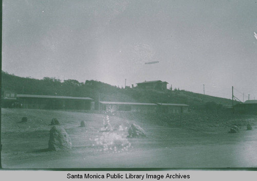 Graf Zeppelin flying over Pacific Palisades and Temescal Canyon with machine sheds in the foreground