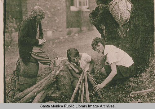 Three young girls (Girl Scouts) building a campfire in Temescal Canyon, Pacific Palisades, Calif