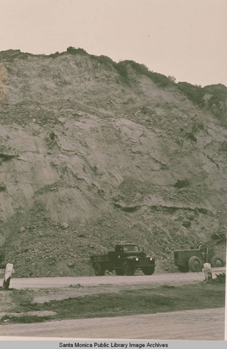 Trucks and construction equipment on Pacific Coast Highway after a landslide