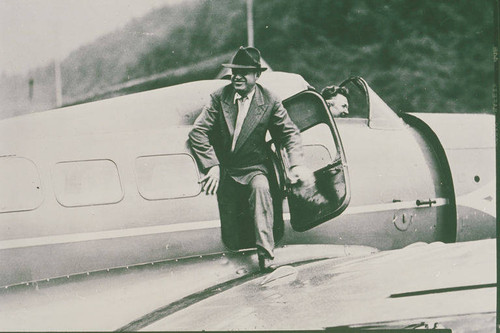 Will Rogers climbing out of an airplane with Wiley Post in the cockpit