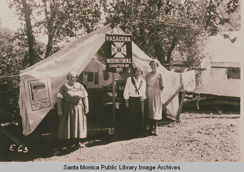 Three women pose by a tent with the banner "Pasadena E.L. Washington M.E. Chapter No. 7971" at Institute Camp, Temescal Canyon, Calif