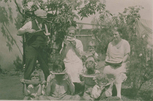 Adults and children eating watermelon in Pacific Palisades, Calif