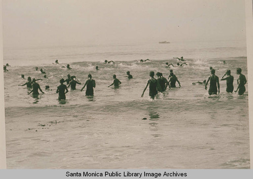 Swimmers wading into the surf at the start of a competition near Pacific Palisades, Calif