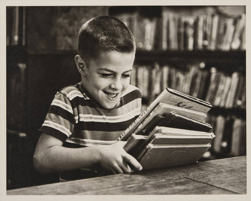 Boy holding a stack of books