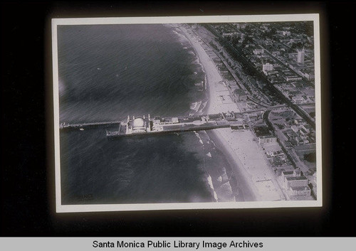 Aerial of the Santa Monica Pier looking west with the Crocker Bank Building and clock tower in upper right corner; Del Mar Beach Club at lower right, October 4, 1933, flown at 12:20PM