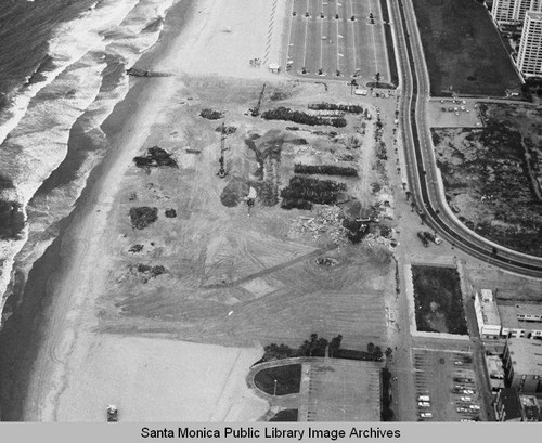 Looking north from the remains of the Pacific Ocean Park Pier at beach parking lots and the Santa Monica Shores Apartments, April 17, 1975, 11:50 AM