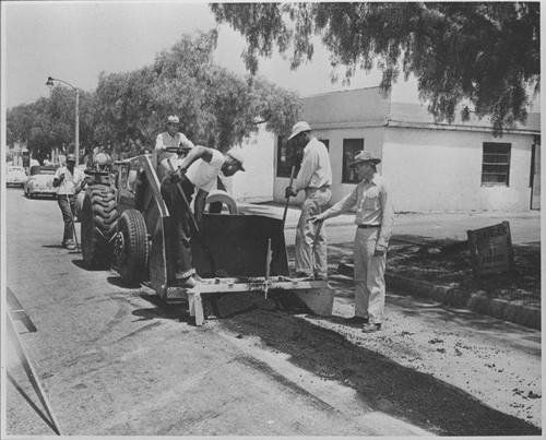 Santa Monica City workers paving a street using equipment with a "Les Moore design" attachment, July 1, 1951