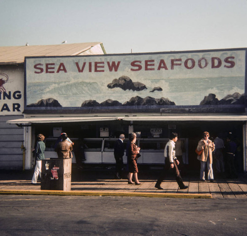 People walking by Sea View Seafoods on Santa Monica Pier