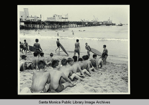 Junior Lifeguards from the Santa Monica Lifeguard Service with paddle boards at the beach north of the Santa Monica Pier on August 3, 1954