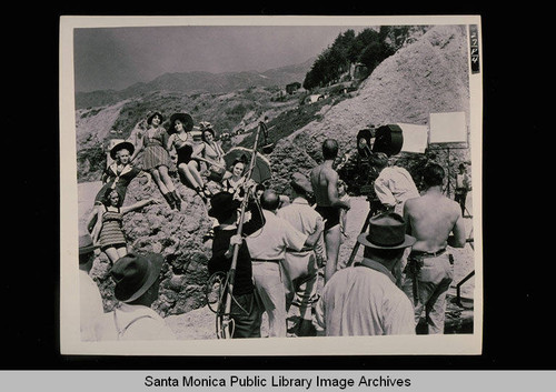 Alice Faye and her Mack Sennett bathing beauties pose at Castle Rock on Santa Monica Beach