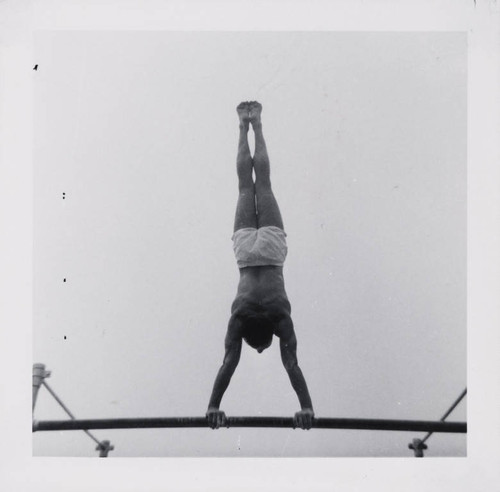 Man working out using pullup bars on Muscle Beach, Santa Monica, Calif