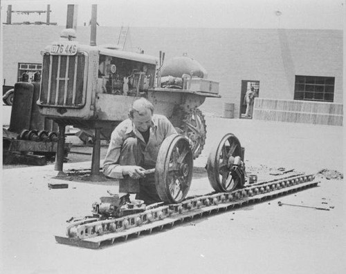 Mechanic doing overhaul of Caterpillar tractor (License Plate E76 446) in the Santa Monica City Yards