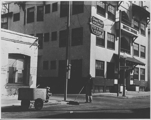 Ocean Park Amusement Pier directional sign above a Santa Monica City worker sweeping the street