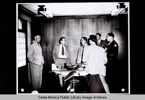 R.A.F. personnel visit with Donald W. Douglas near a display of Douglas Aircraft airplane models