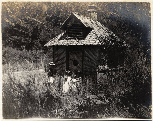 Women and children in front of rustic dwelling, Mandeville Canyon, Calif