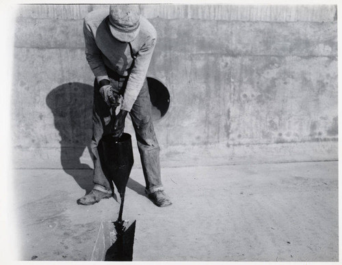 Construction of the Santa Monica Municipal Swimming Pool, pouring mastic in expansion joints, December 21, 1950