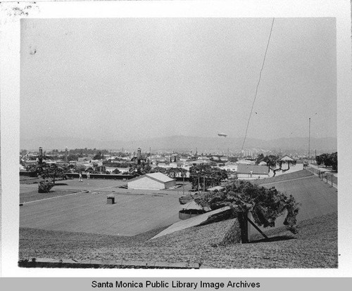 Dirigible (airship) hovers over the camouflage designed by landscape architect Edward Huntsman-Trout during World War II to cover the Douglas Aircraft Company plant in Santa Monica, Calif