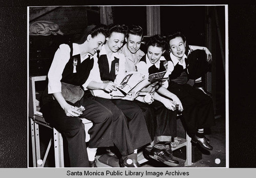 Douglas Aircraft Company employees share an issue of "Motion Picture" magazine for a publicity shot during World War II