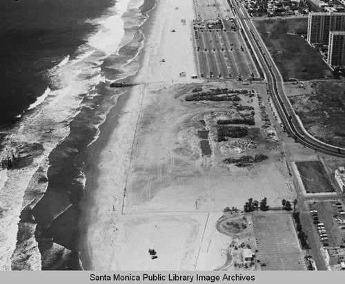 Looking north from the remains of the Pacific Ocean Park Pier to beach parking lots and the Santa Monica Shores Apartments, May 20, 1975, 1:30 PM