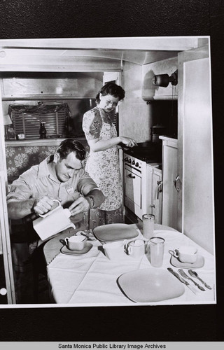 Couple in trailer home kitchen, Douglas Aircraft Company employee housing, World War II