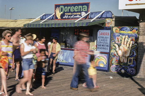 People walking by Doreena the fortune teller on Santa Monica Pier