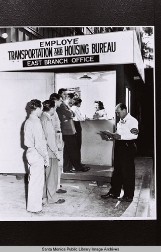 Clerk handles a line of housing applicants at the Employee Transportation and Housing Bureau East Branch Office for Douglas Aircraft Company employee housing during World War II