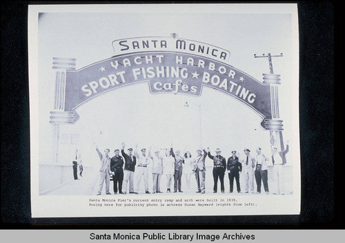 Santa Monica Pier sign and entry ramp built in 1939 publicity photo with actress Susan Hayward (eighth from left)