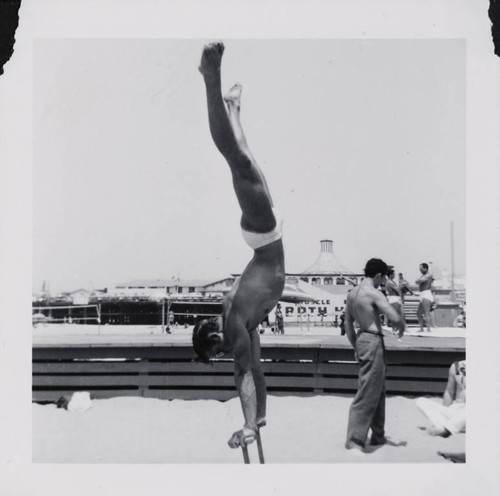 Man working out using pushup stands on Muscle Beach, Santa Monica, Calif