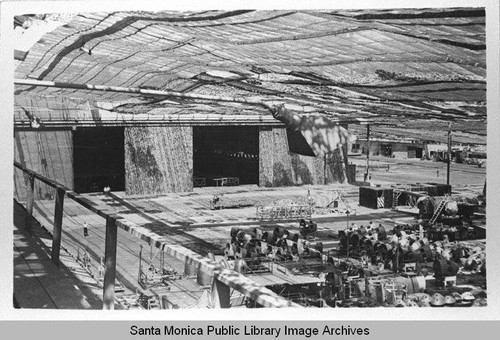 Hangars and aircraft parts at the Douglas Aircraft Company Santa Monica plant under the camouflage designed by landscape architect Edward Huntsman-Trout to conceal the manufacture of military aircraft during World War II