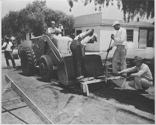 Santa Monica City workers paving a street using equipment with a "Les Moore design" attachment, July 1, 1951